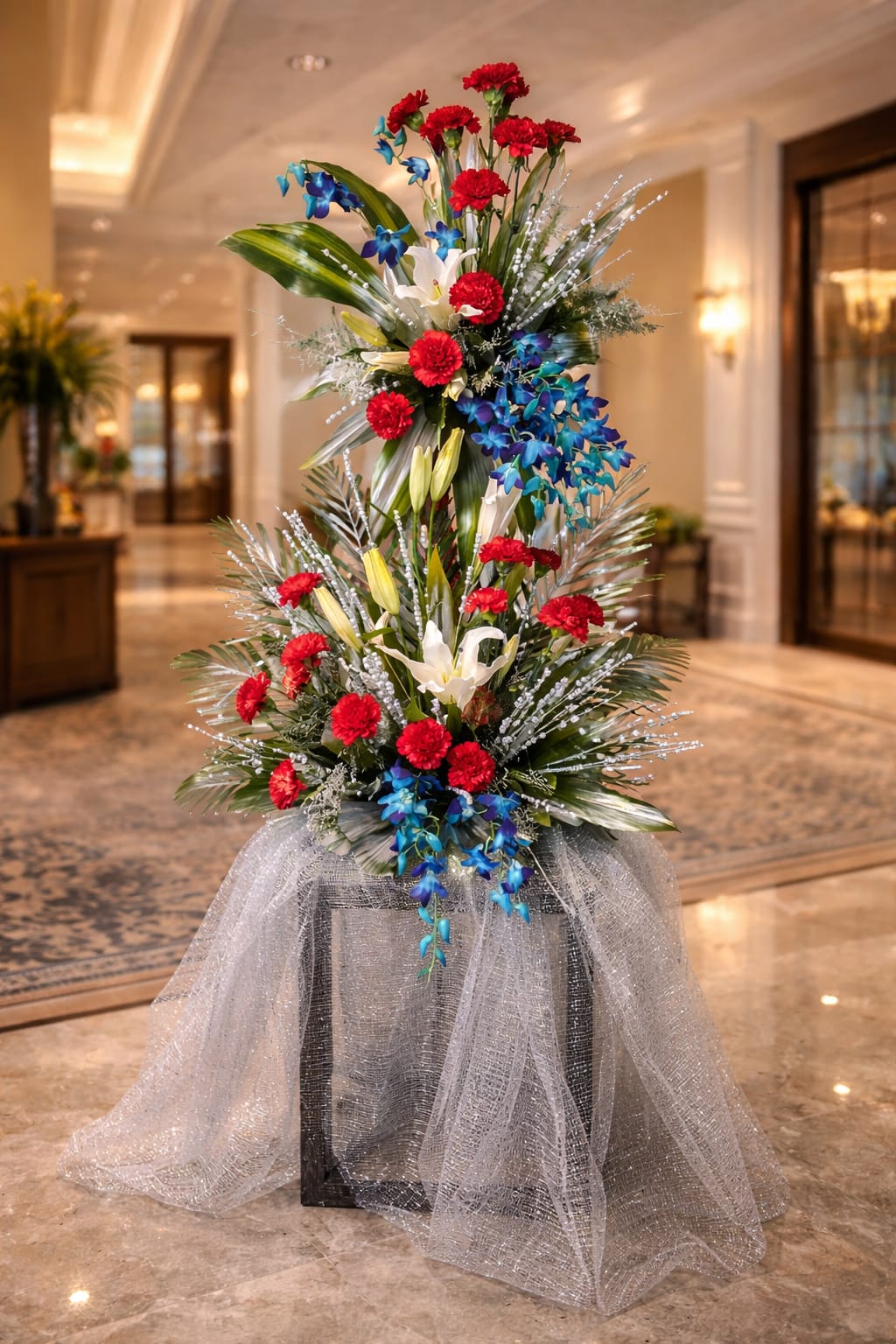 A bold, patriotic-inspired mix of deep crimson red, vibrant royal blue, and pure white, accented by lush greenery and silver textures.